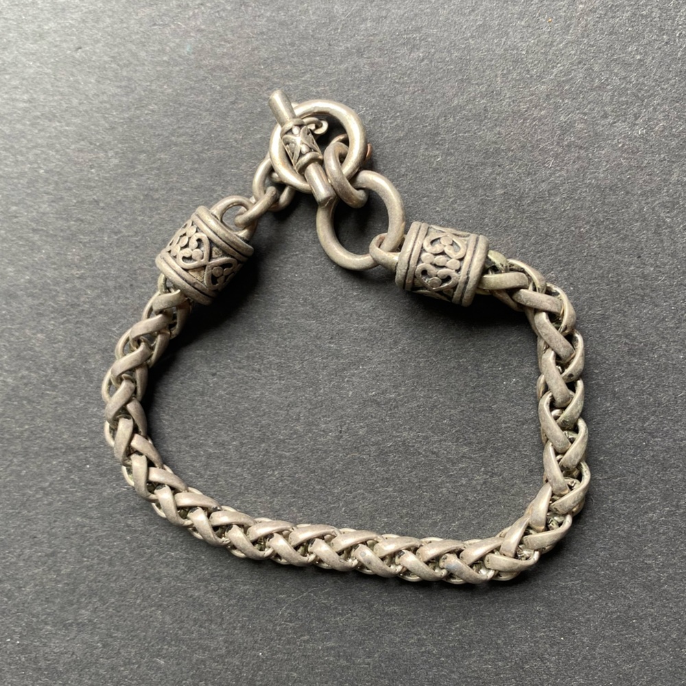 Designer Indonesian silver toned braided bracelet with toggle closure